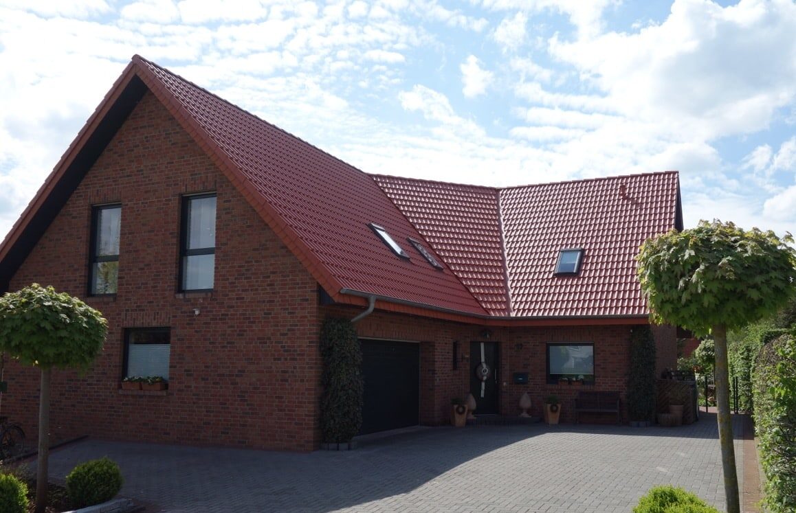 Modernes Backsteinhaus mit rotem Dach im Grünen, Foto von Bautenschutz Bogumil GmbH.