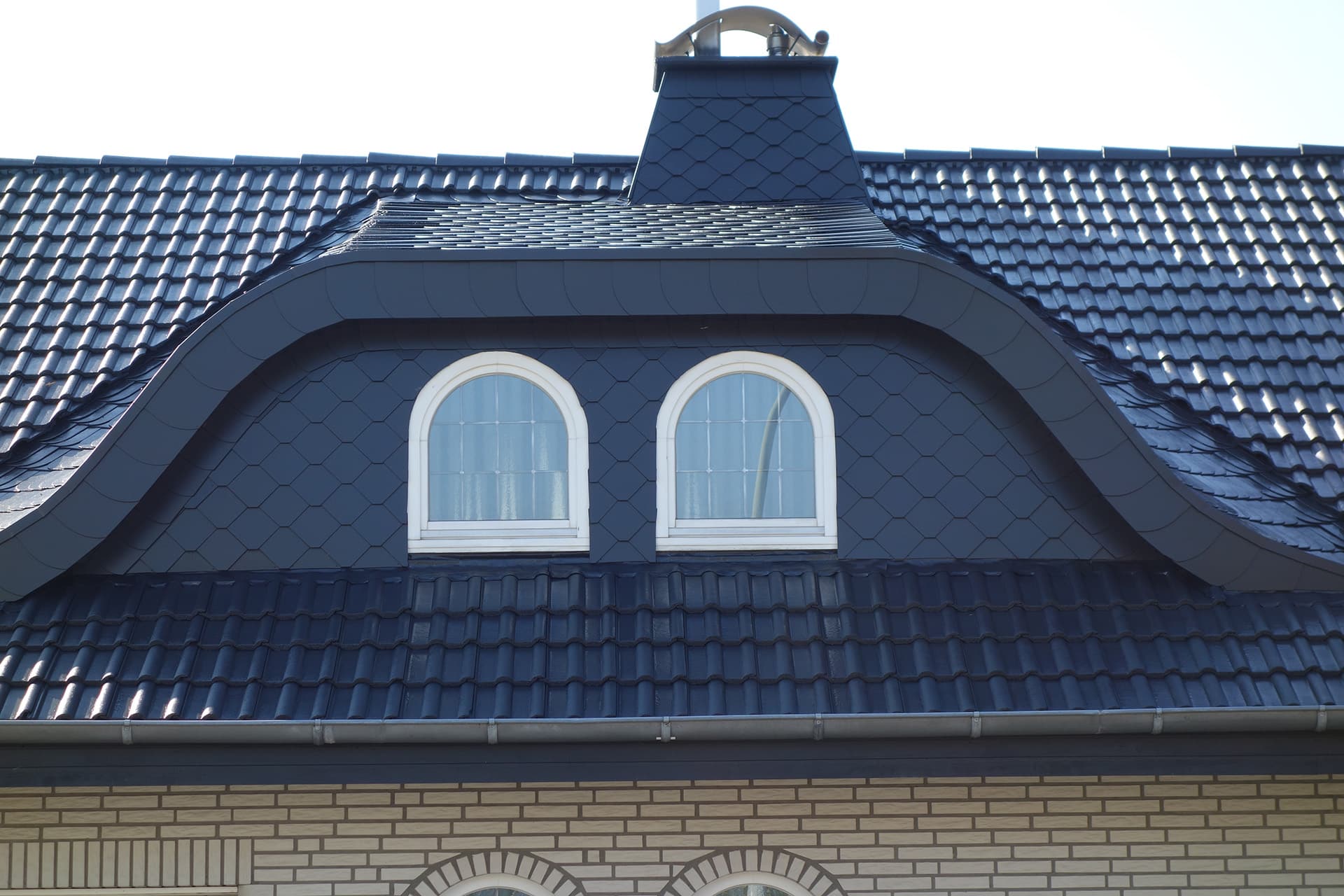 Dach mit zwei Fenstern und Ziegeln in Blau; Arbeit von Bautenschutz Bogumil GmbH.