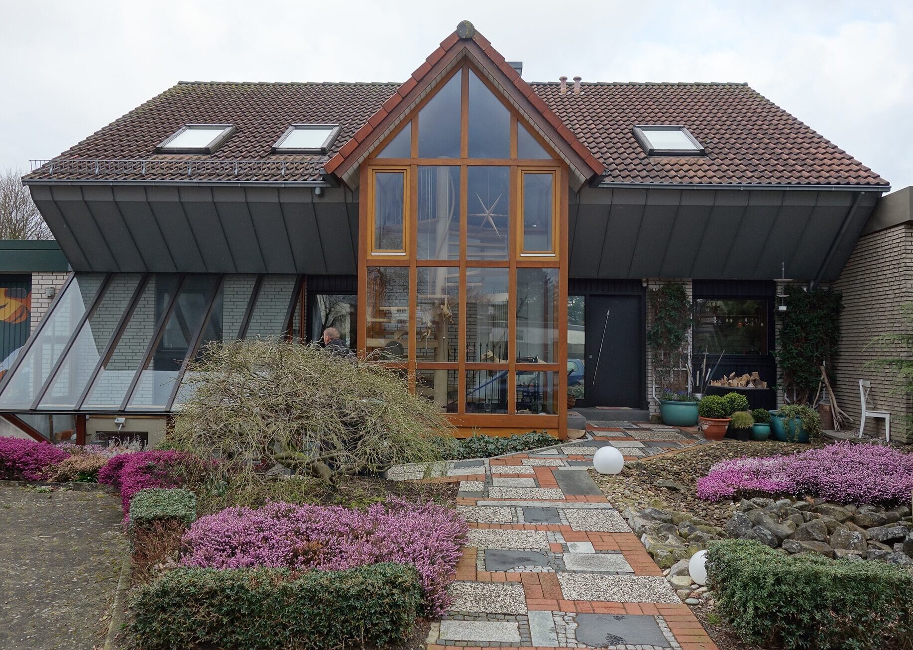 Modernes Haus mit großem Glasfenster und gepflegtem Vorgarten, möglicherweise in Verbindung mit Bautenschutz Bogumil GmbH.