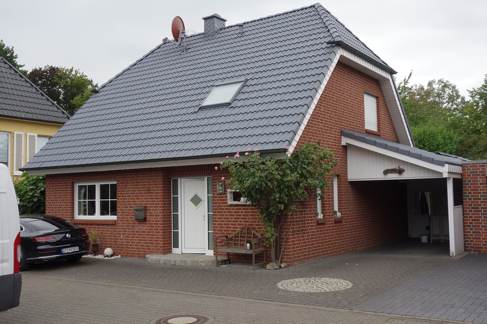 Ein Einfamilienhaus mit rotem Klinker und grauem Dach, aufgenommen im Zusammenhang mit Bautenschutz Bogumil GmbH.