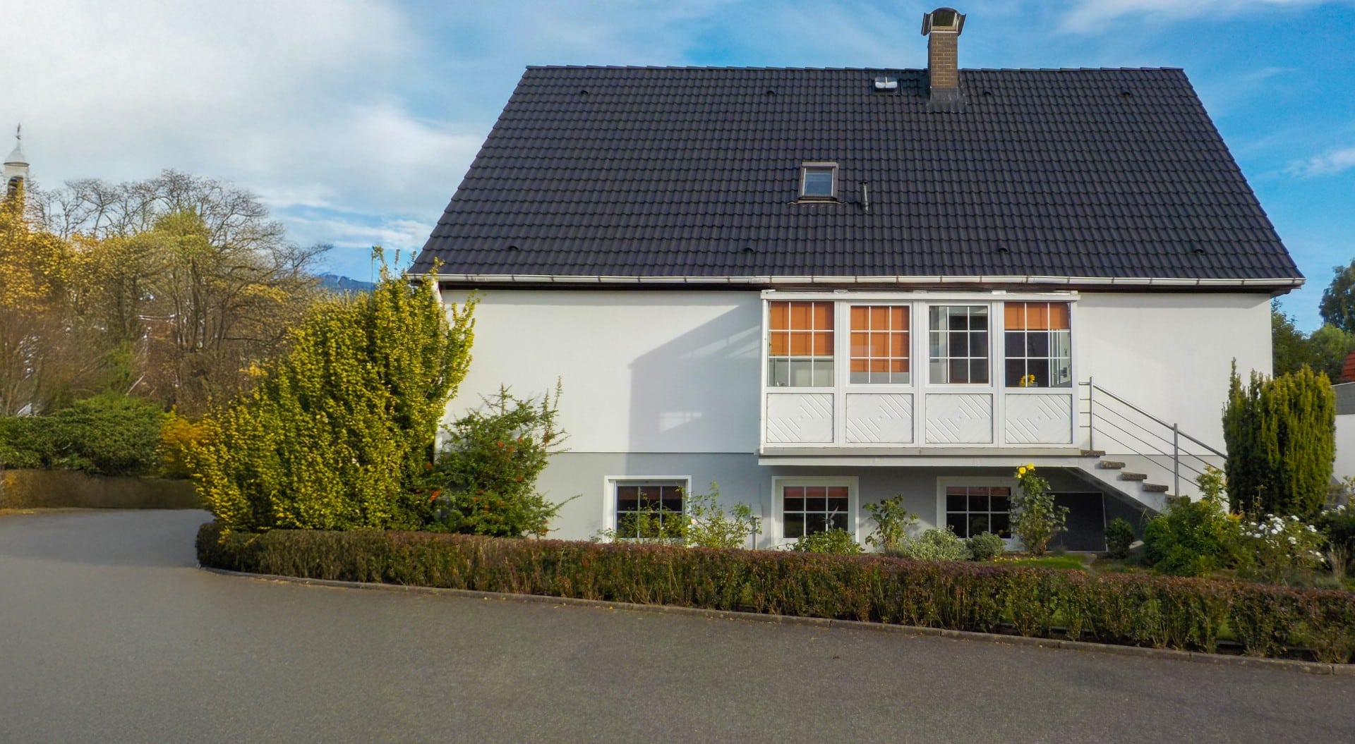 Ein renoviertes Haus mit gepflegtem Garten, instand gehalten von Bautenschutz Bogumil GmbH.